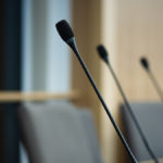 close up of microphones in a council chamber candidates