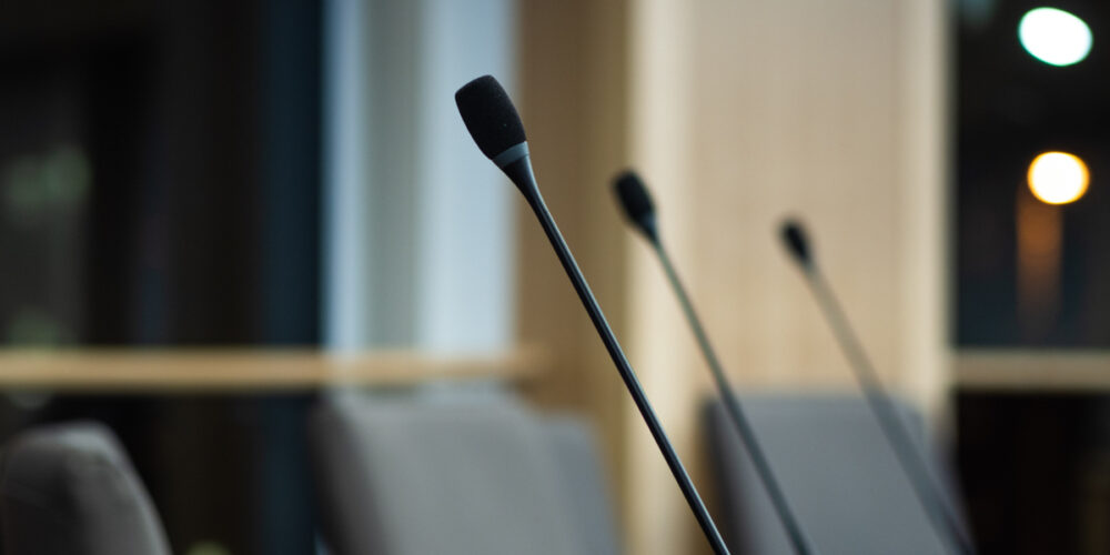 close up of microphones in a council chamber candidates