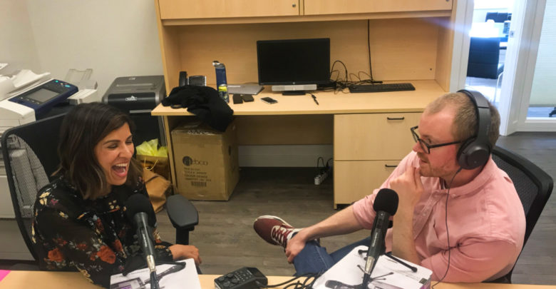 man and woman sit with podcast microphones to record What the Job