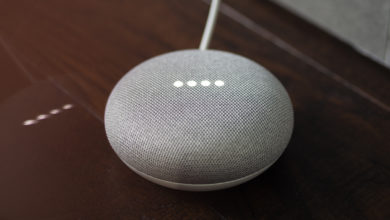 a grey google home mini on wooden floor