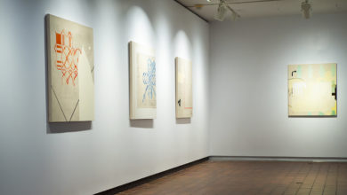 Kim McCollum paintings hanging in a gallery wall