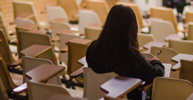 person studying in empty classroom marking grading