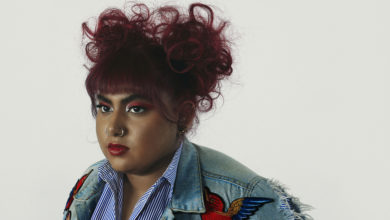 Headshot of woman with red hair and denim jacket