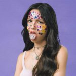 teenage girl with stickers on face sticking tongue out