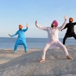 Five Indian Sikh men Bhangra dancing on rocks