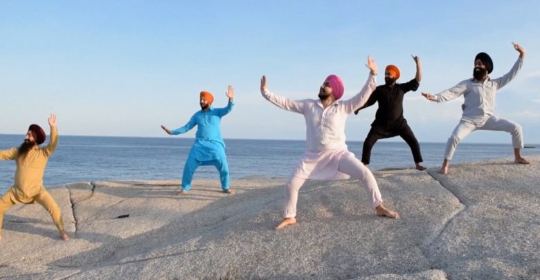 Five Indian Sikh men Bhangra dancing on rocks