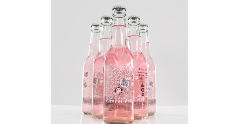 An image of the POPOPOPOPOP bottles. They are glass bottles full of pink soda with a label on the front.
