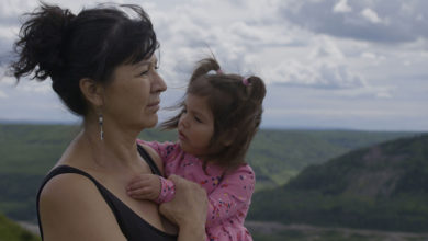 A scene from Wochiigii lo: End of the Peace, showing Diane Abel holding her granddaughter.