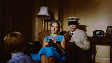 A scene from The Nature of Nicholas with Nicholas's mother sitting down and his father hanging over her shoulder.