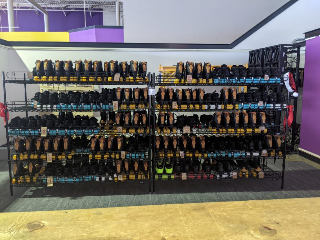 A lineup of for-rent roller skating shoes.