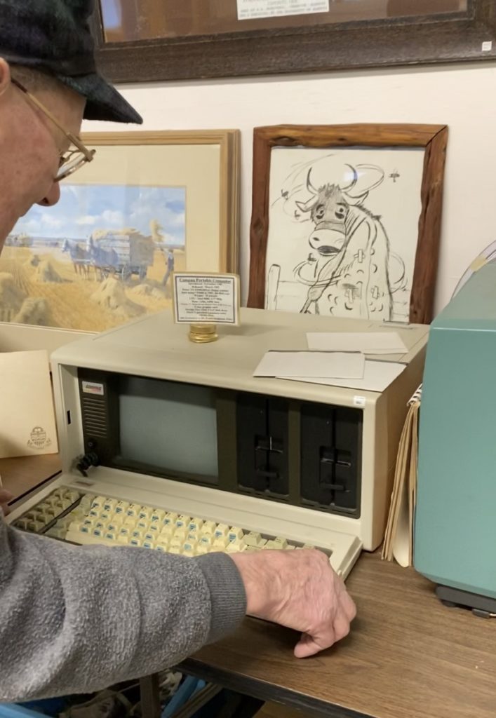 Jack Francis shows off an old-timey computer. It looks like a microwave.
