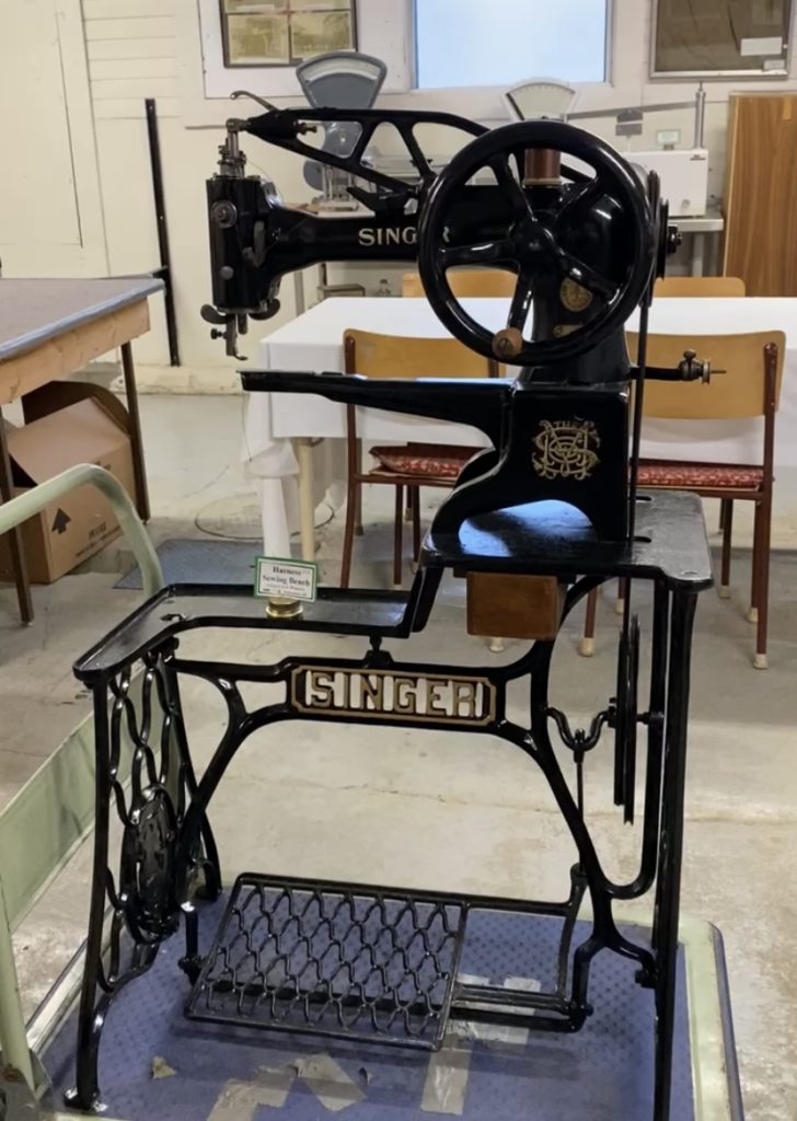 A photo of a sewing machine from the ALES Museum. It has a black frame.