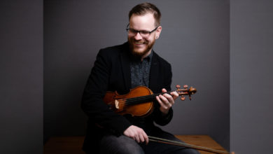 Arlan Vriens holding a violin in his lap.