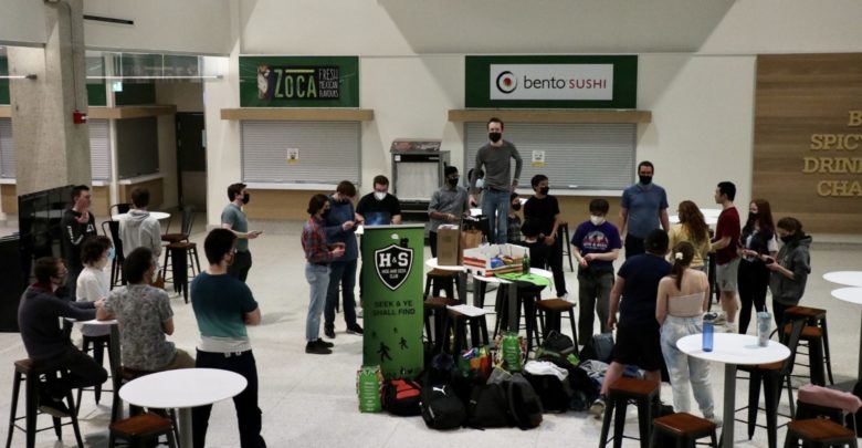 A group of people gather in the basement of CAB for the Hide and Seek Club meeting