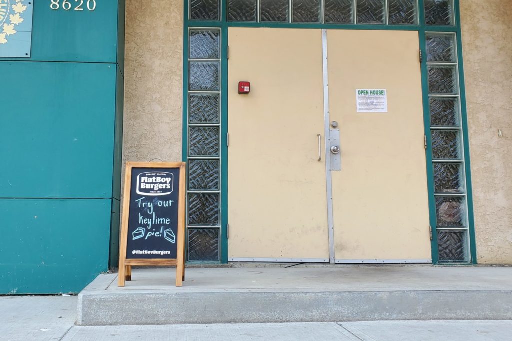 The Flat Boy Burgers chalkboard showcasing their key lime pie dessert outside the Granite Curling Club