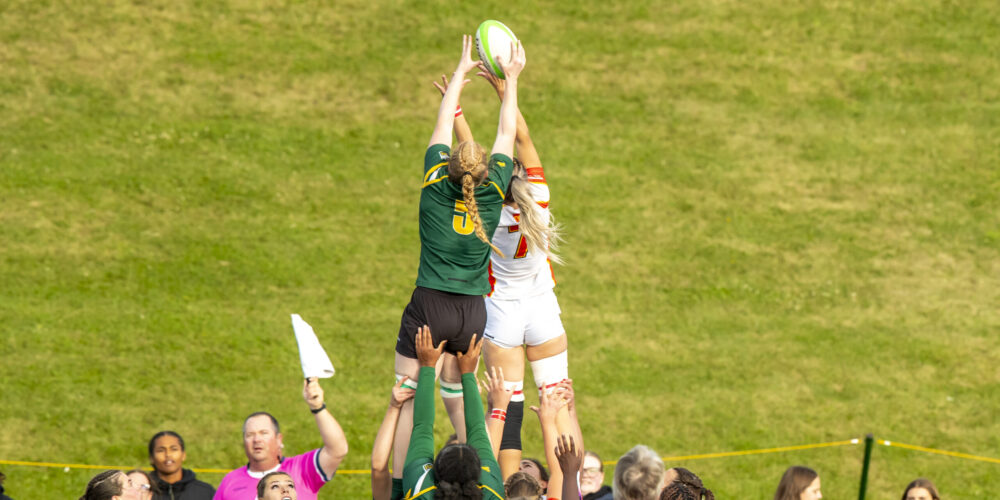 Panda and Dino player get hoisted into the air by teammates to reach the rugby ball